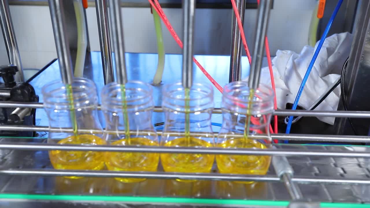 cinta transportadora, jugo en botellas en la planta de bebidas o interior de la fábrica en color azul, línea de producción industrial, tonada