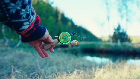 equipos de pesca en el hielo de primer plano en la mano de un hombre