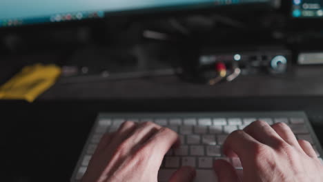 close-up pov of male fingers typing on a computer keyboard, depicting work and technology use