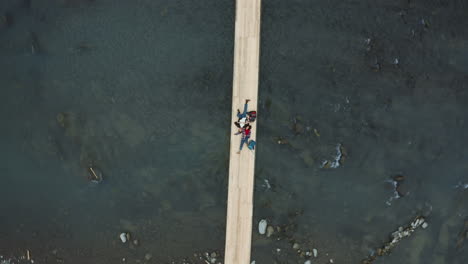 Young-male-and-female-couple-resting-lying-down-on-mountain-bridge-with-backpacks