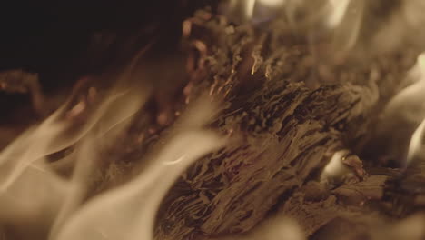 slowmotion shot of a fire and flames burning away a newspaper in a fire pit creating sparks and smoke log