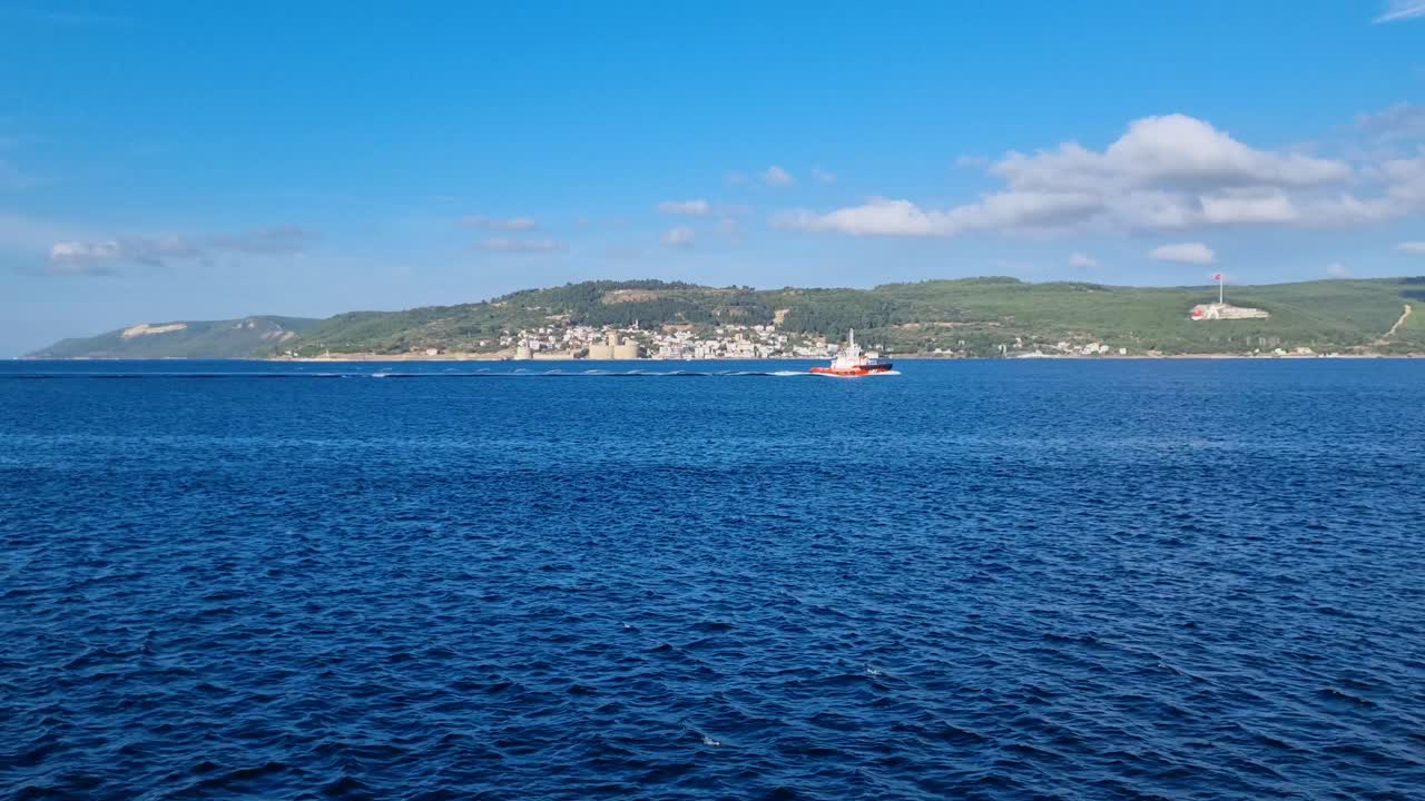 Shot of the Dardanelles Strait in Turkey on a sunny day, with gently rippling blue waters and the Gallipoli Peninsula visible on the horizon