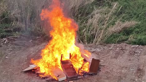 gran hoguera en el parque fuera de la ciudad, quemando cosas viejas y innecesarias usadas. destrucción y quema de artículos viejos en la calle en primavera.