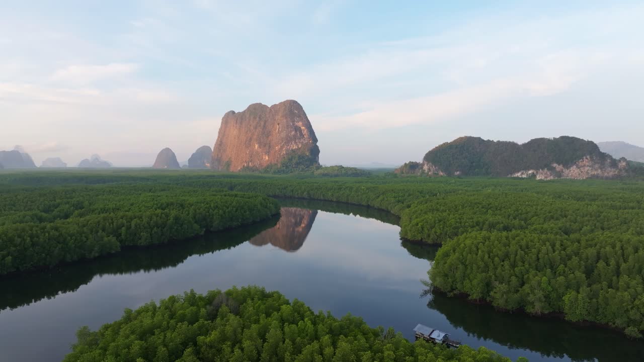 Tayland'da bir kazık evin arkasından koyu altın rengine bürünen gün doğumu.