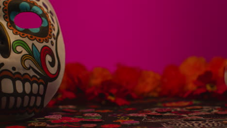 still life of decorated skull masks with flowers celebrating mexican holiday of dia de muertos or day of the dead against dark background 1