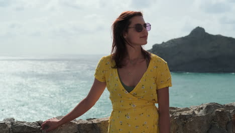 woman in yellow dress by the ocean