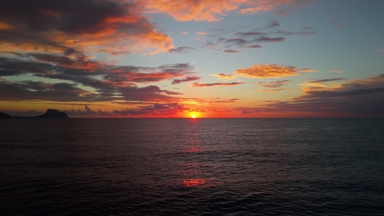Vibrant Sunset Over Calm Ocean with Colorful Clouds