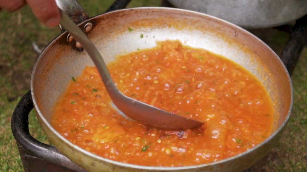 estufa de camping cocinando salsa y revolviendo en sartén 1