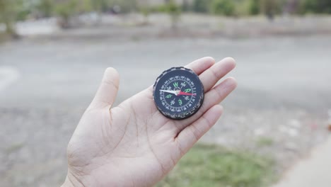 close up, black compass in a transparent hand.