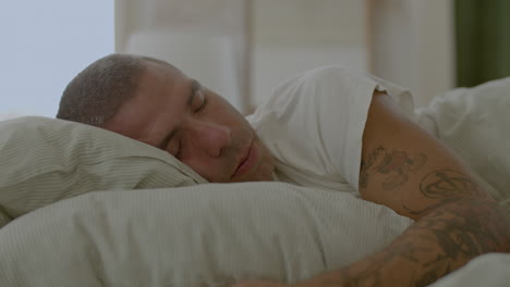 hombre caucásico guapo durmiendo en la cama en casa