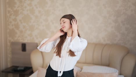 Hermosa-Joven-Escucha-Música-Con-Auriculares-Y-Baila-En-La-Cama