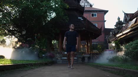 man walking through a thai temple complex