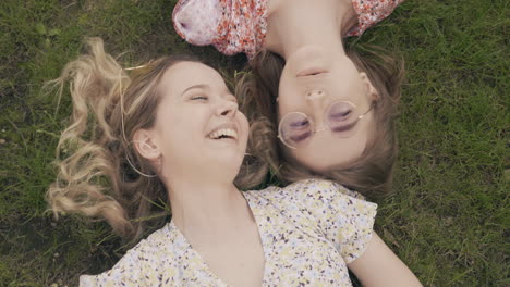 two women friends lying on grass