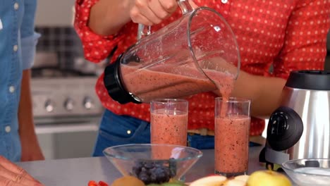 woman pouring smoothie in a glass