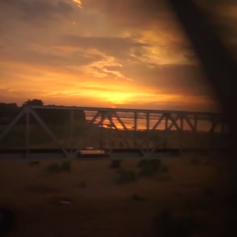 View-from-outside-the-windows-of-an-express-train,-evening-with-colorful-sky