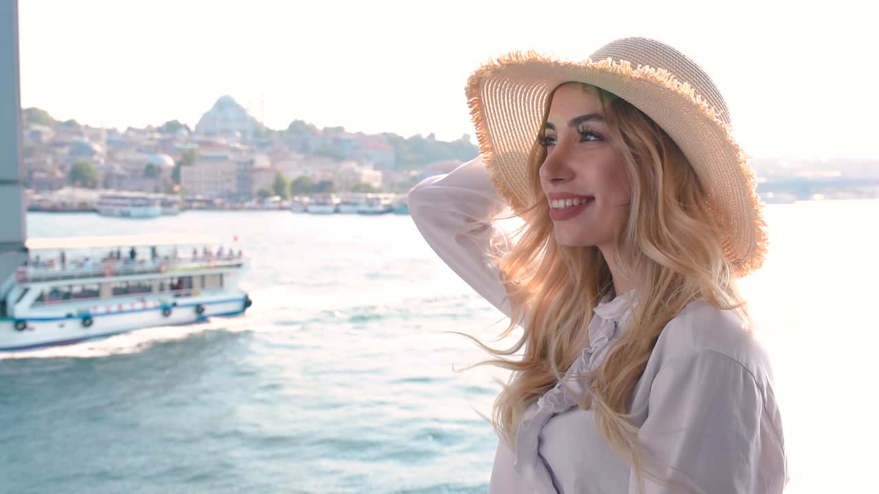 Slow Motion: Bella ragazza posa sul Ponte di Galata e si gode la vista del Bosforo e della Moschea di Solimano a Istanbul, Turchia