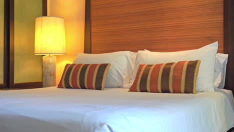 striped accent pillows on large comfortable bed in modern luxury resort suite