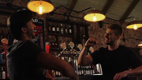 two male friends giving high five to each other at counter