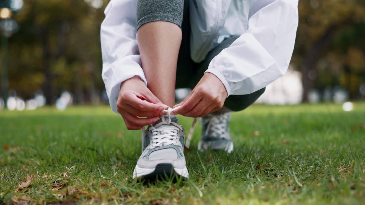Fitness, mani e donna che allaccia i lacci delle scarpe prima