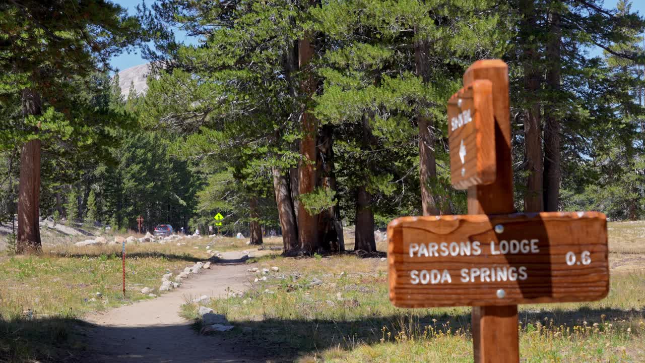 4K close-up captures a weather-worn wooden trail signpost for Soda Springs in Tuolumne Meadows, Yosemite National Park. Perfect B-roll for travel, hiking, nature, or outdoor-adventure projects