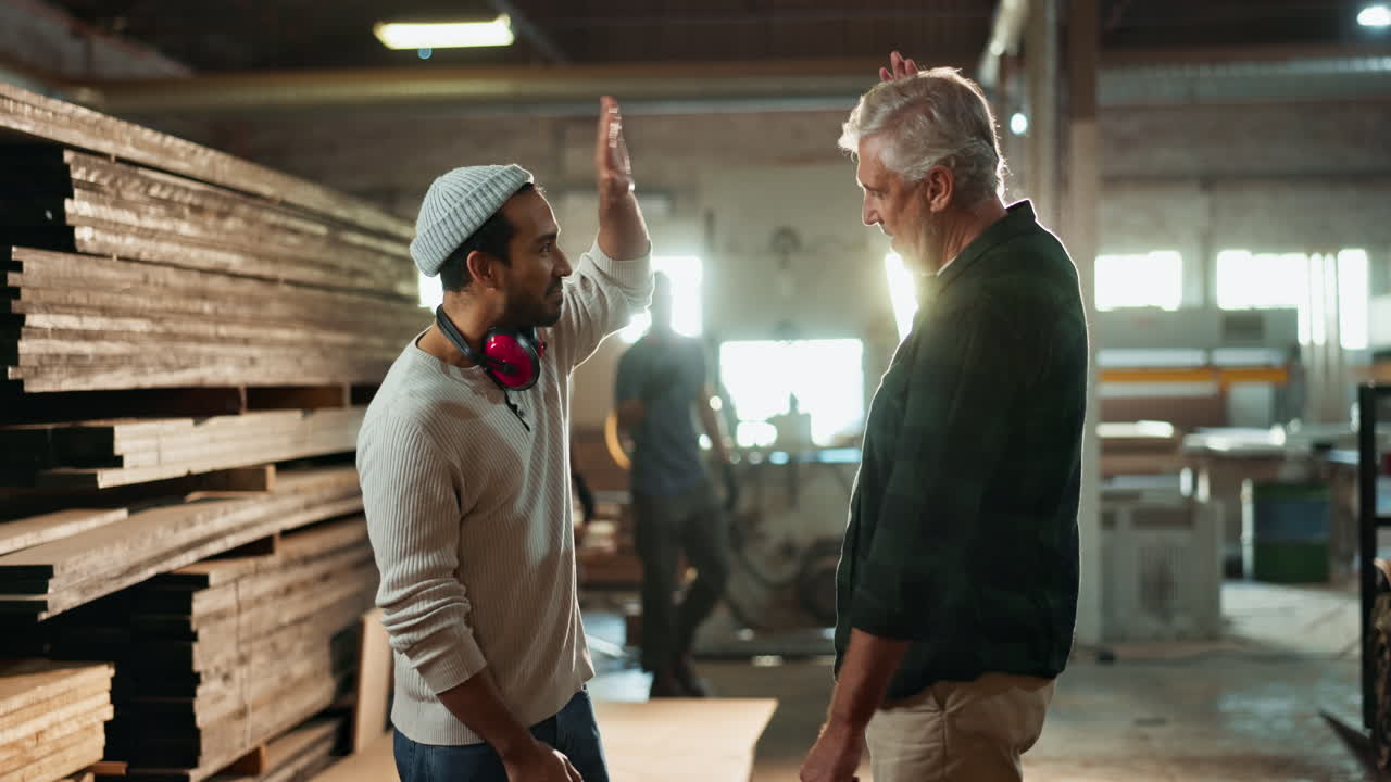 Carpenters high-fiving in a woodshop