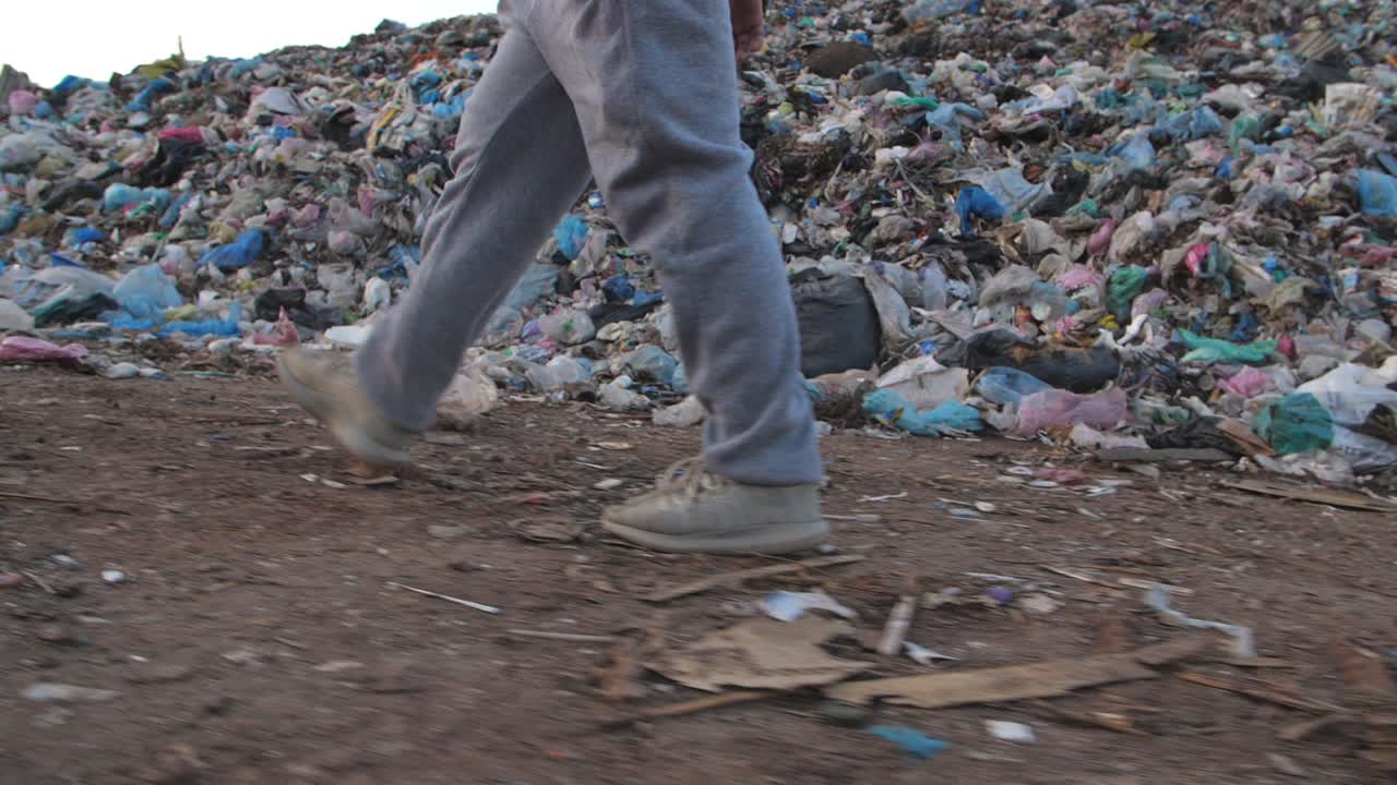 Legs Boy Walking Near Garbage Pile, Slow Motion