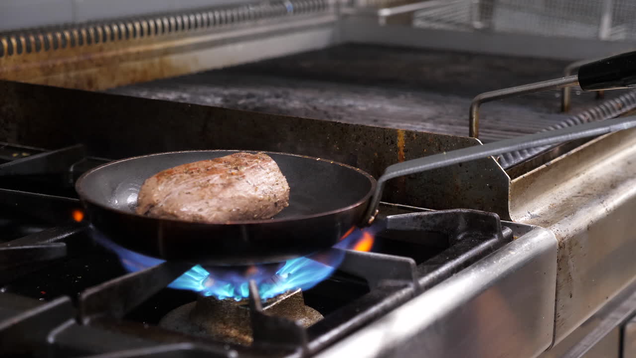 Kött som tillagas i en panna på en spis