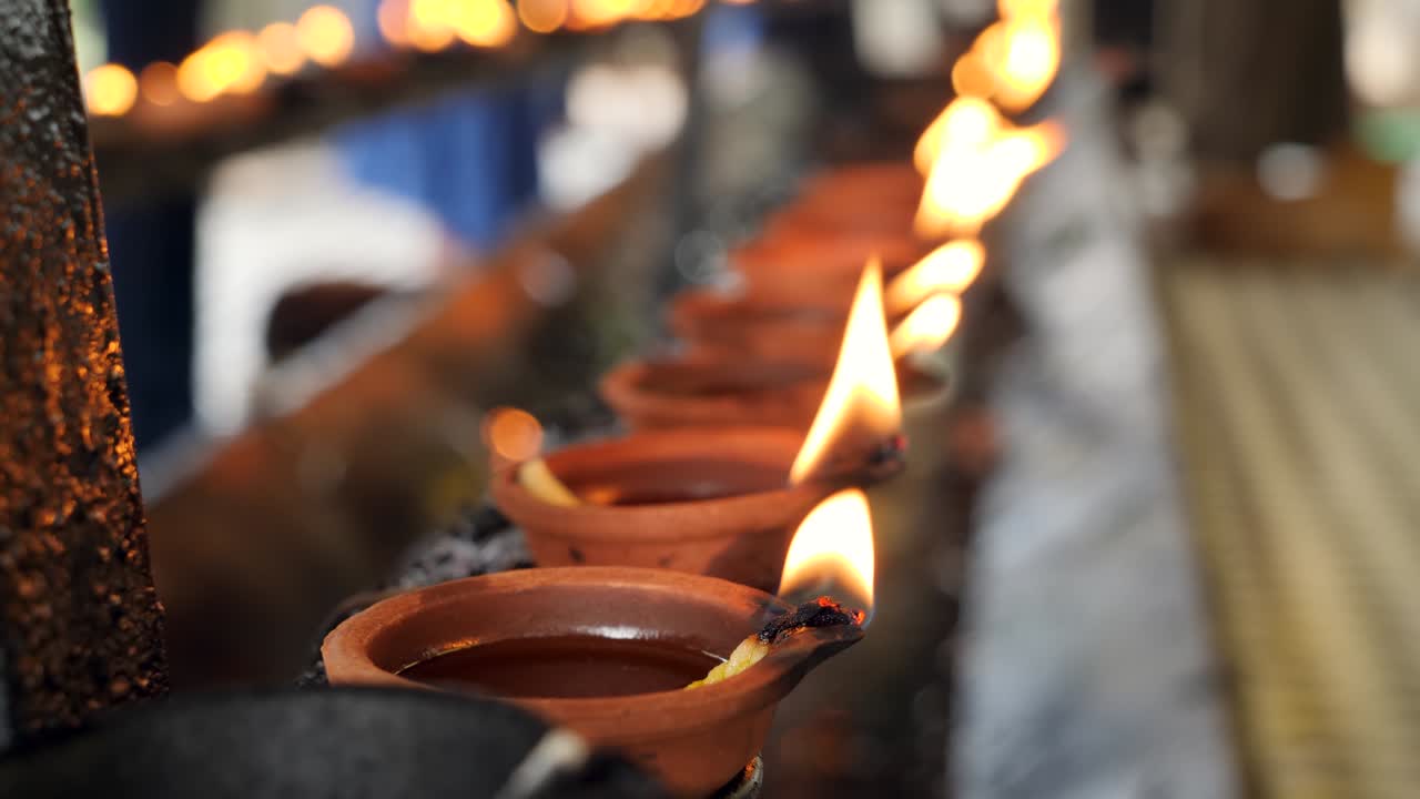 video en 4k de fuego sagrado en linternas de aceite en un templo hindú o budista en sri lanka