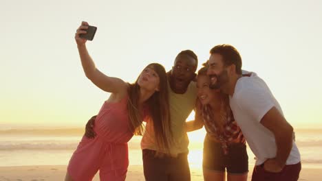 amigos adultos jóvenes tomando moscas en la playa al atardecer 4k