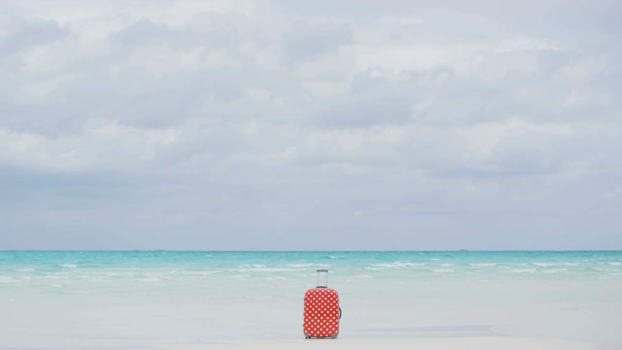 푸르키즈 바다에 의해 열대 해변에서 여행 수하물