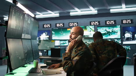 Military-officer-receiving-telephone-call-while-looking-at-intel-files