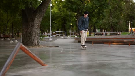 Junger-Skateboarder,-Der-Flip-Ollie-Trick-Auf-Einem-Speziellen-Geländer-Im-Skatepark-Skatet-Und-Springt