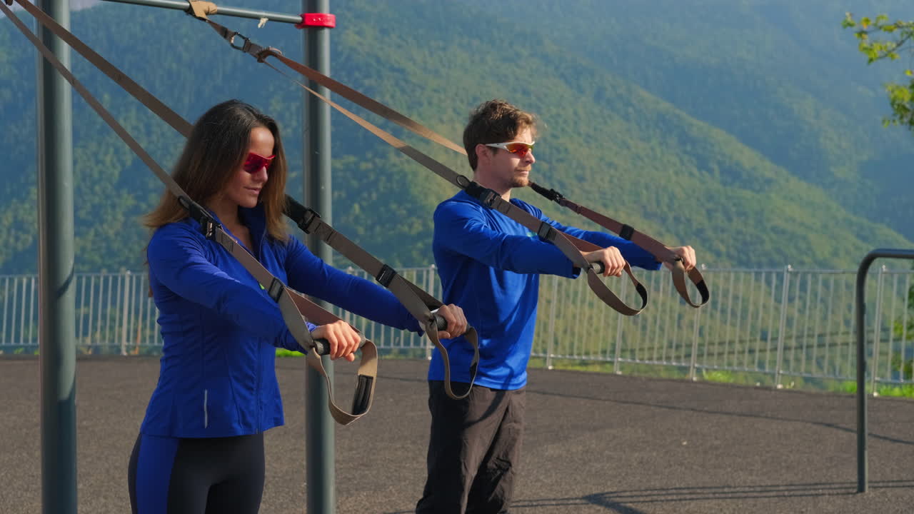 서스펜션 트레이닝으로 야외 운동을 하는 커플