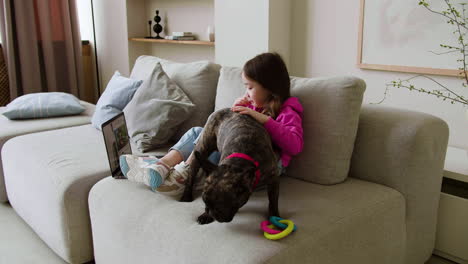 girl petting dog at home