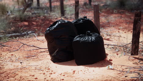 Primer-Plano-De-Bolsas-De-Basura-Llenas-En-La-Arena