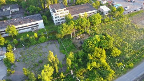 old white factory buildings. aerial shot of an old abandoned big factoty with a long smoke stack