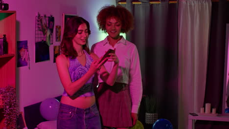 friends taking selfies in a colorful room