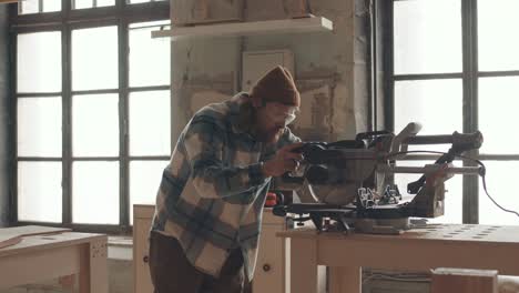 male carpenter using circular saw while working