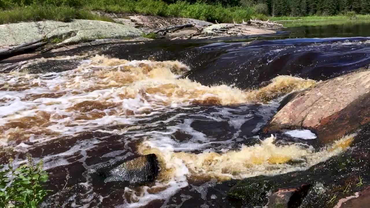 Etomami River Onakamees Rapids Boreal shield river in summer slow motion Northern Manitoba Canada