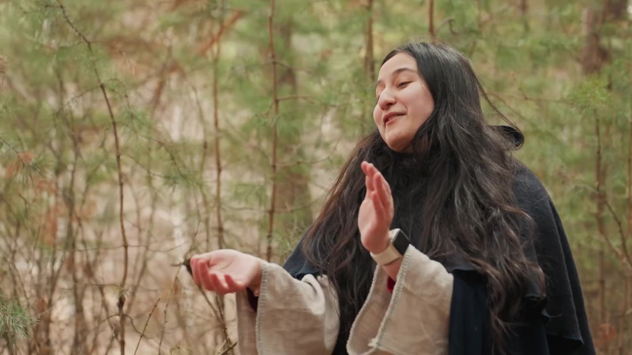 Una mujer alegre aplaudiendo y sonriendo en un exuberante entorno forestal, rodeada de tonos verdes y marrones, que encarna actividades al aire libre y felicidad. Esta escena es editorial y natural.
