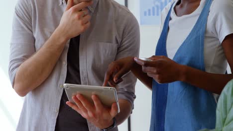 front view of young mixed-race business team working on digital tablet in a modern office 4k