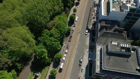 wide, reversing aerial video of the luas tram system operating in dublin city centre, county leinster, ireland, on a bright and sunny day. filmed in 4k, 60fps and with rec709 color.