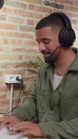 A man wearing a headset in front of a brick wall