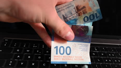 un utente di laptop mostra banconote