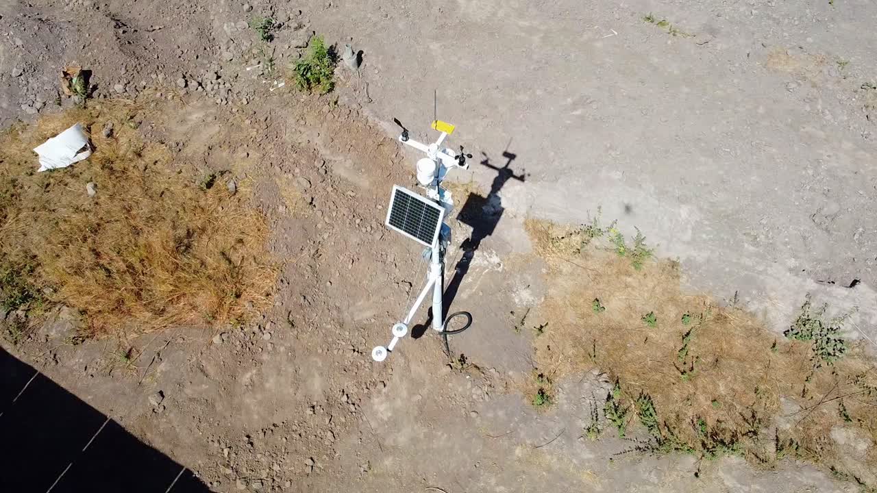 Aerial view away from a weather station at a solar farm, sunny day in Africa