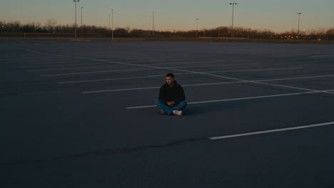 man meditating in empty parking lot