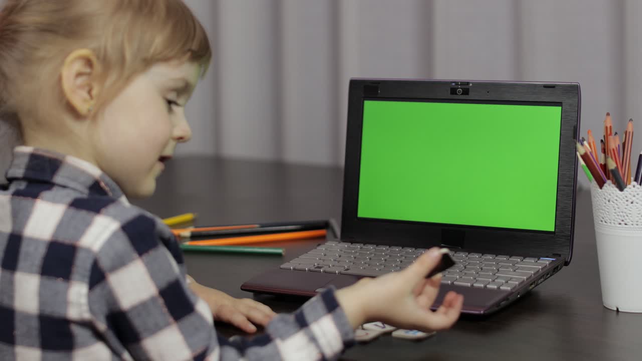 educación a distancia de los niños en la computadora portátil durante la lección en línea en casa. pantalla verde