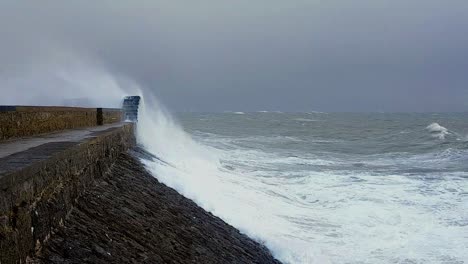 waves crashing onto sea defences porthcawl lighthouse south wales during storm atiyah in slow motion