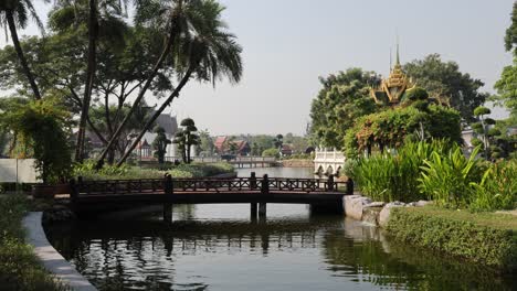 people crossing a picturesque bridge in a lush park