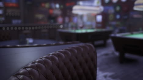 interior of a busy pool hall with dim lighting and green tables